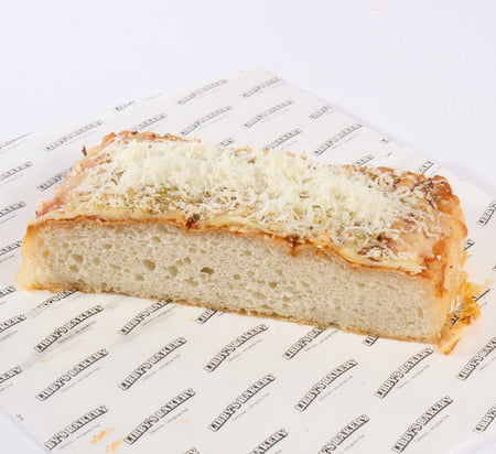 A slice of foccacia pizza with cheese on a libbys logo paper background