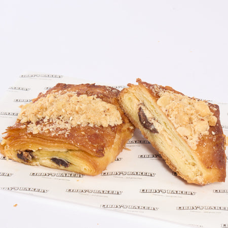 Gluten free praline pain au chocolat one slice cut in half on a white surface
