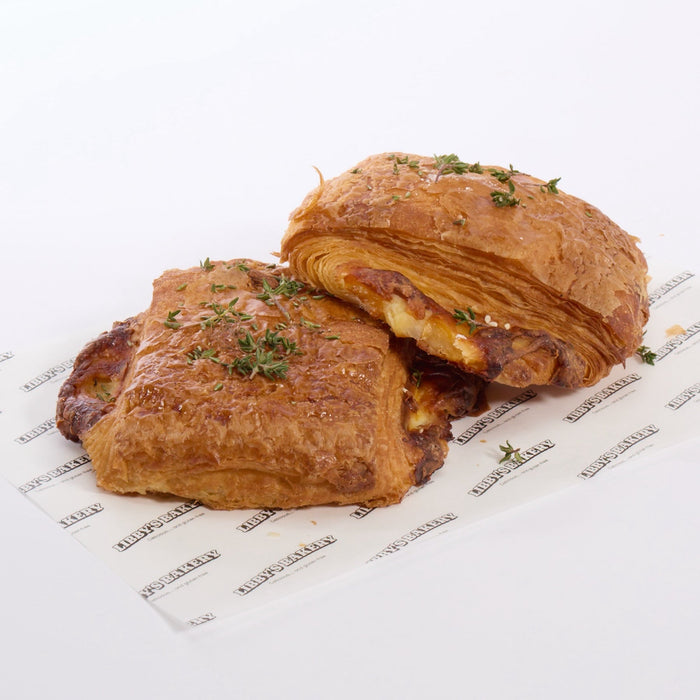 Two GF sausage roll croissants on a white surface with a libbys bakery paper 