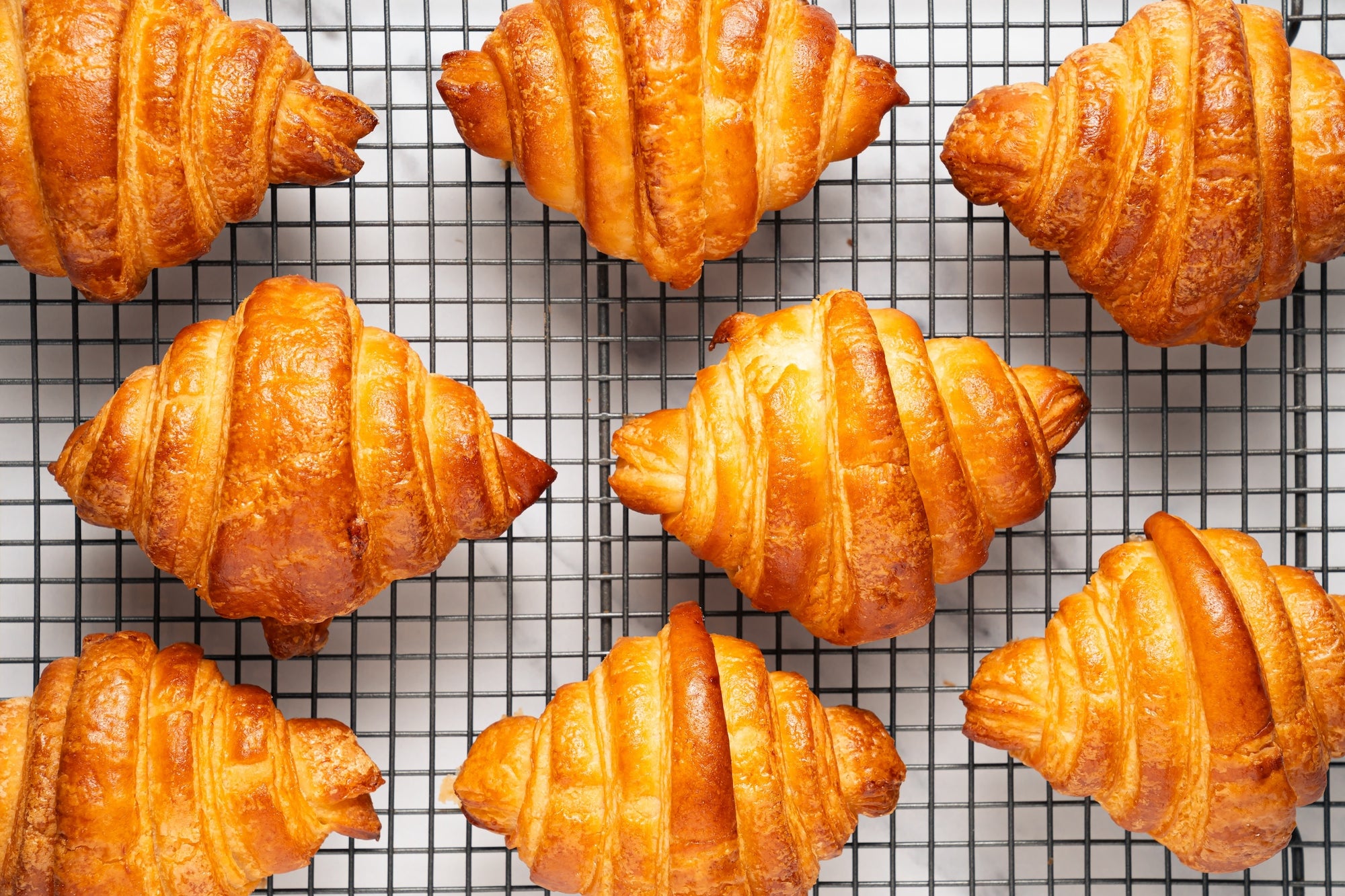 a steel tray showing eight croissants