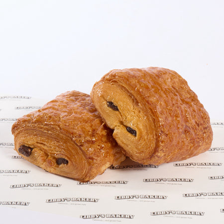 Two pain au chocolat on a white surface with 'libbys Bakery' branding