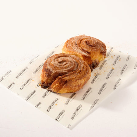 Two Libby's gluten free cinnamon buns on Libby's branded paper