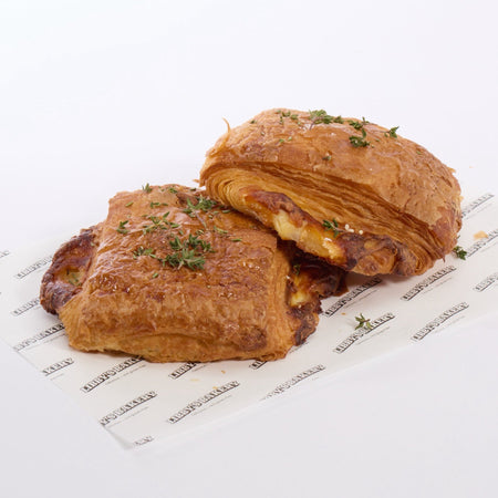 Two GF sausage roll croissants on a white surface with a libbys bakery paper 
