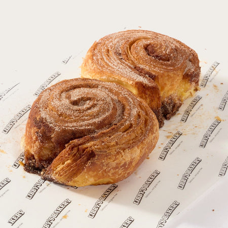 Two Libby's gluten free cinnamon buns on Libby's branded paper