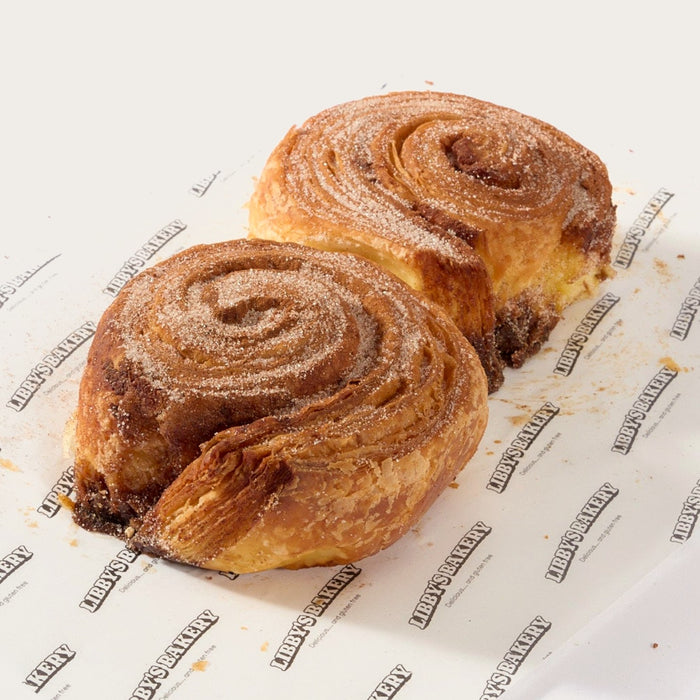 Two Libby's gluten free cinnamon buns on Libby's branded paper